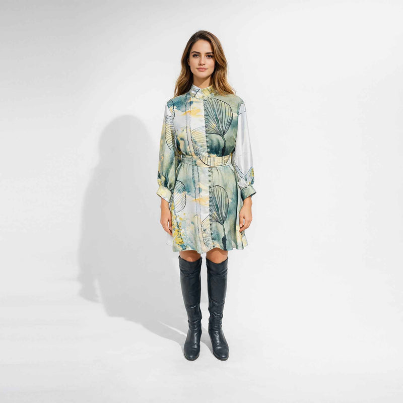 Front view of the multicolor botanical print short dress, belted at the waist, styled with knee-high black boots