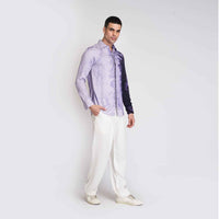 Angled front view of the purple ombre tie-dye shirt with white trousers