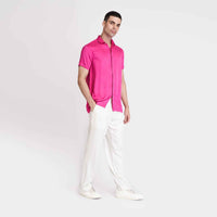 Side view of the solid hot pink camp shirt with white trousers