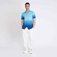 Front view of the blue ombre camp shirt, full length with white trousers