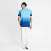 Back view of the blue ombre camp shirt with white trousers