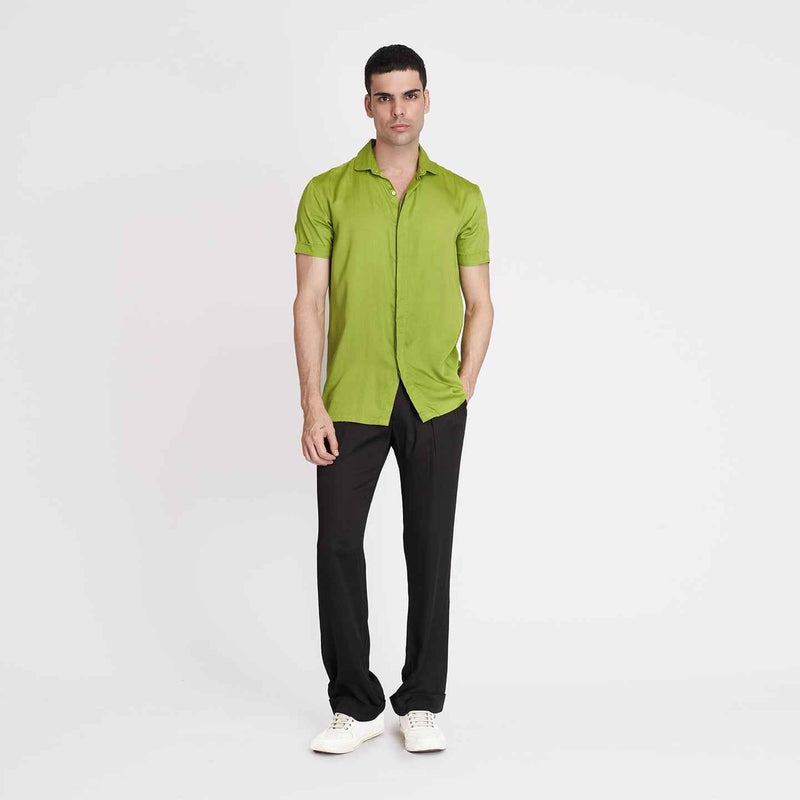 Front view of the solid neon green camp shirt, full length with black trousers