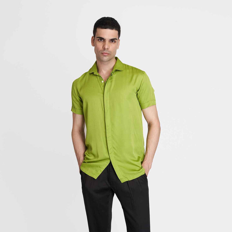 Front view of the solid neon green short-sleeve camp shirt styled with black trousers