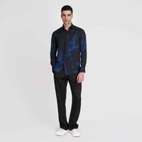 Front view of the black and blue tie-dye print shirt, full length with black trousers