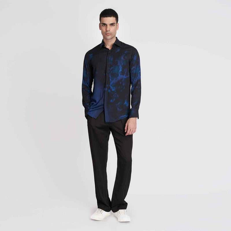 Front view of the black and blue tie-dye print shirt, full length with black trousers