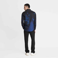 Angled back view of the black and blue tie-dye print shirt