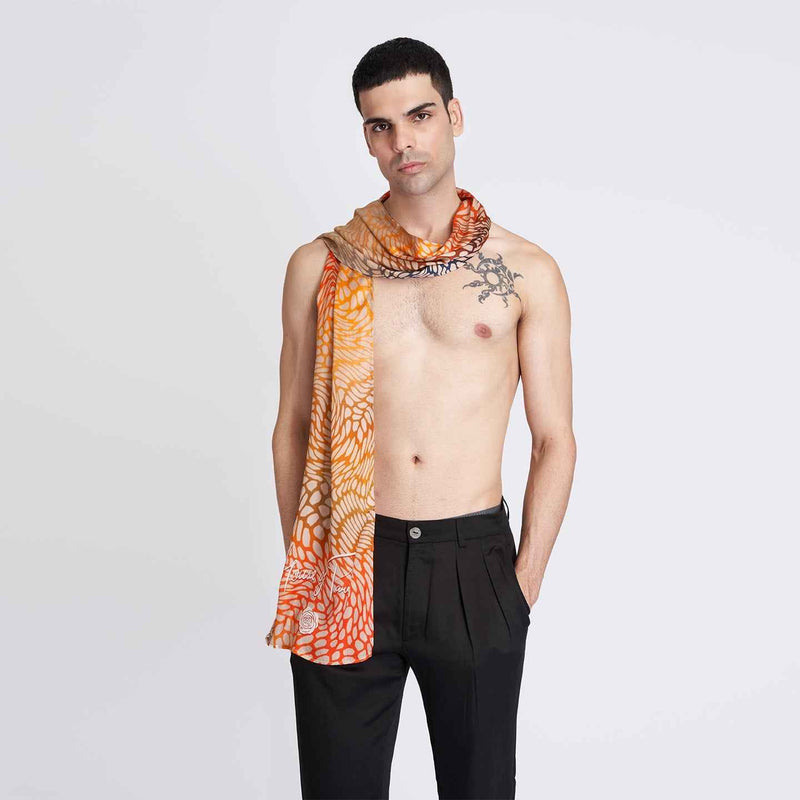 Front view of a man wearing the orange ombre butterfly print scarf with black trousers