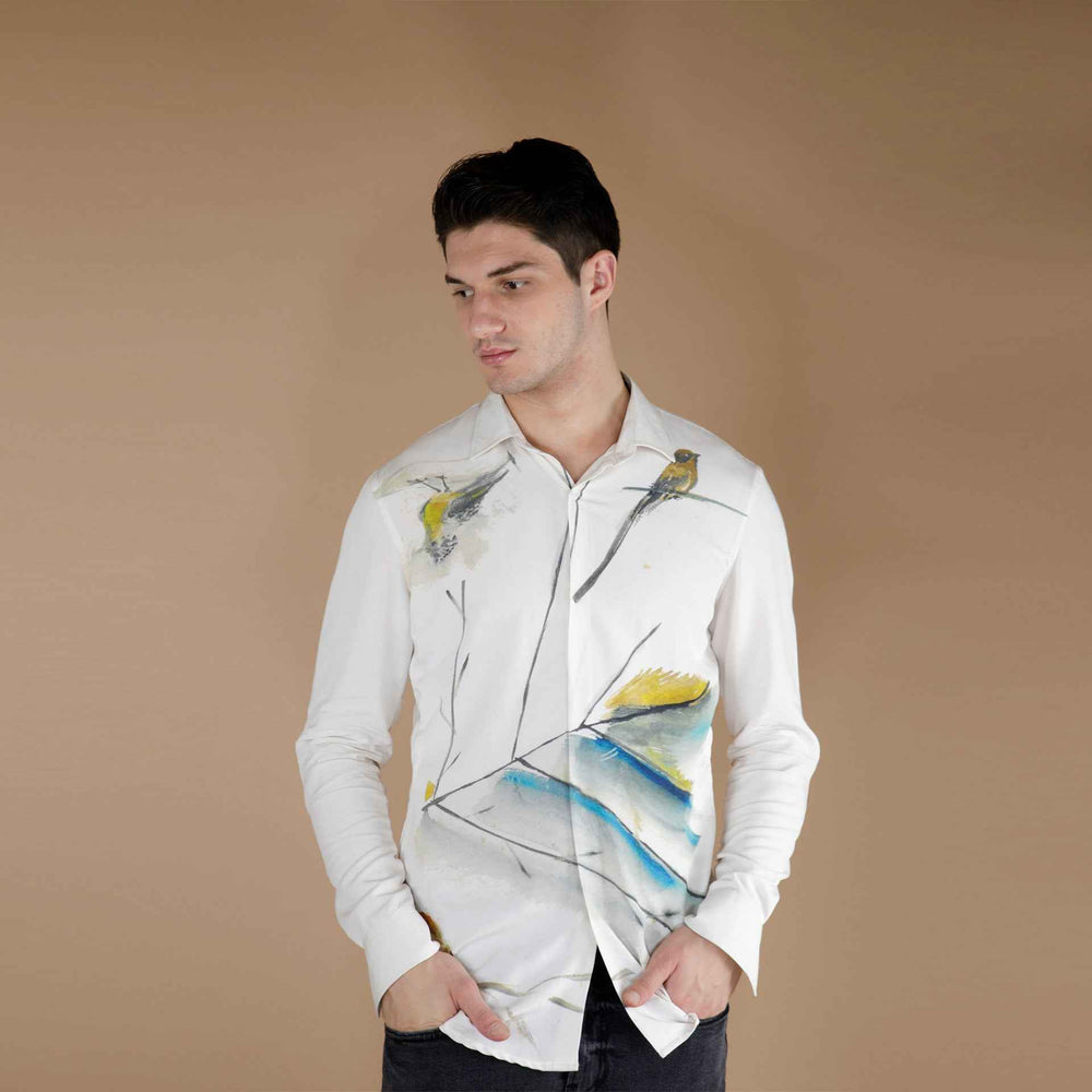 Front view of the white shirt with a hand-painted bird and watercolor branch print
