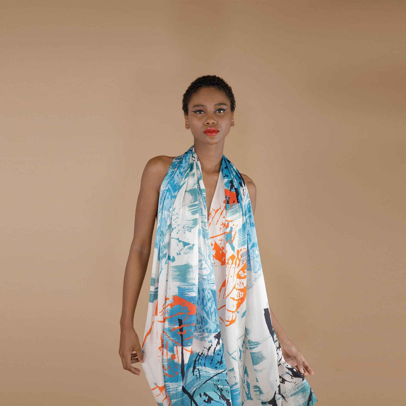 Front view of the blue and orange leaf print scarf worn as a halter wrap dress