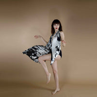 Model in motion wearing the black abstract print scarf as a flowing halter dress