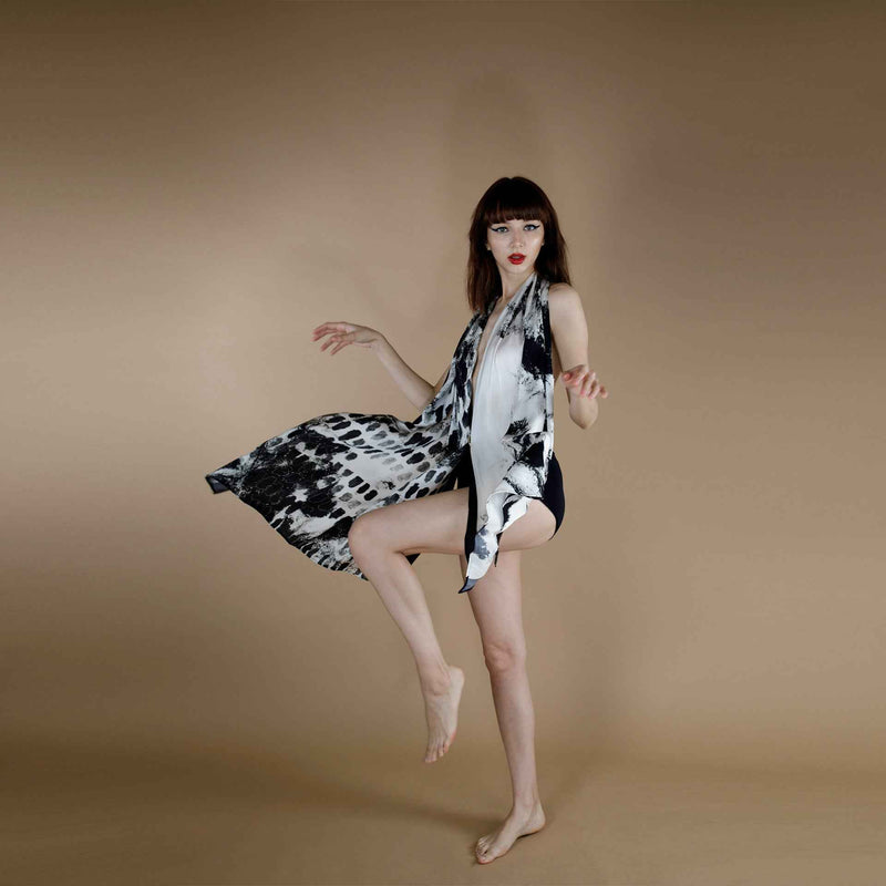 Model in motion wearing the black abstract print scarf as a flowing halter dress