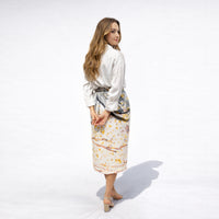 Back-side view of the drip print midi skirt showing the ruched waist detail, paired with a white blouse