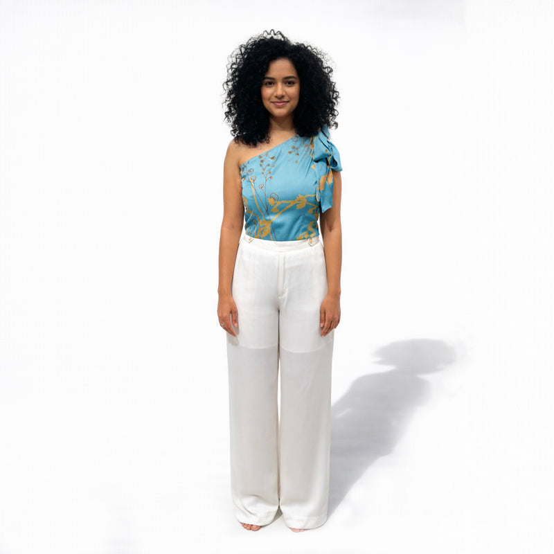 Front view of the teal floral one-shoulder top and white wide-leg trousers, full length