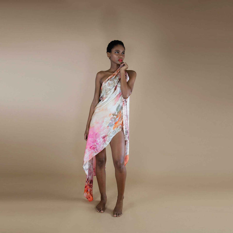 Front view of the pink and orange watercolor floral print scarf worn as a one-shoulder wrap dress