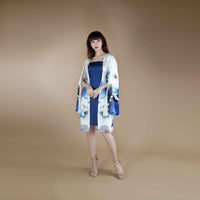 Front view of the blue slip dress layered under a blue and white floral kimono topper