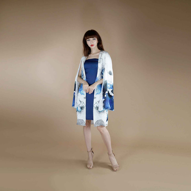 Front view of the blue slip dress layered under a blue and white floral kimono topper