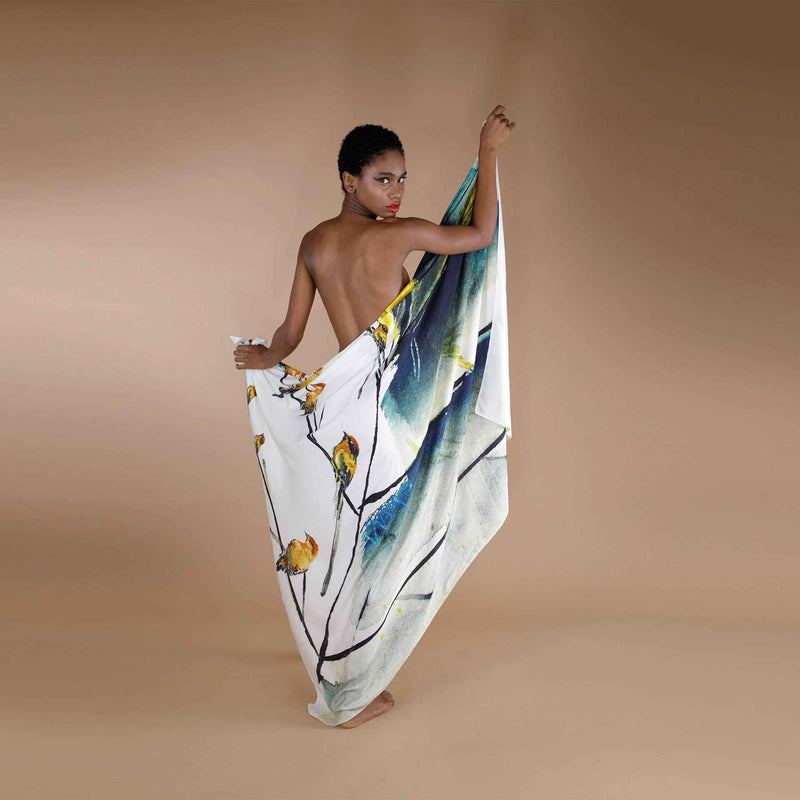 Model draped in the white scarf with a yellow floral and bird watercolor print