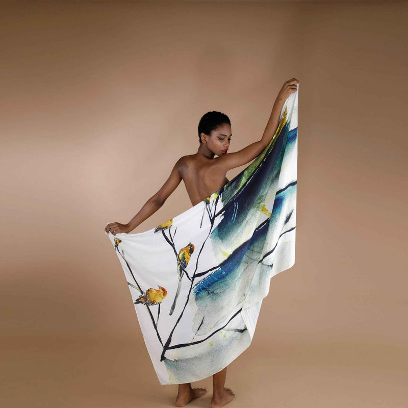 Close-up of the white scarf with a yellow floral and bird watercolor print, draped around the body