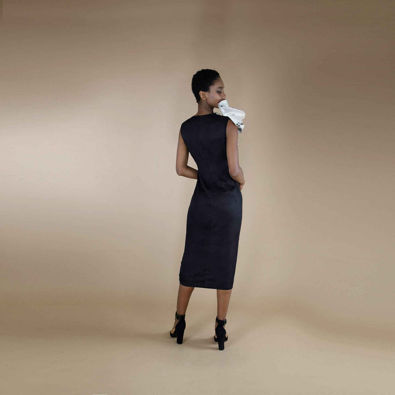 Back view of the black midi dress with a rosette shoulder detail