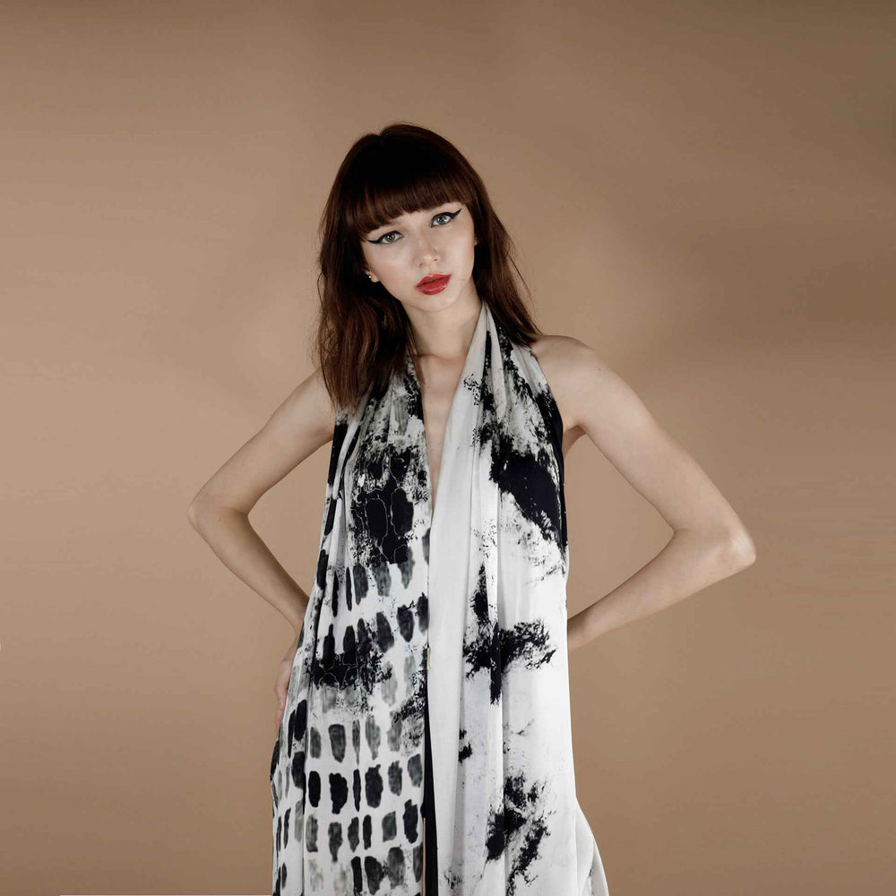 Front view of the black abstract brush-stroke print scarf worn as a halter wrap dress
