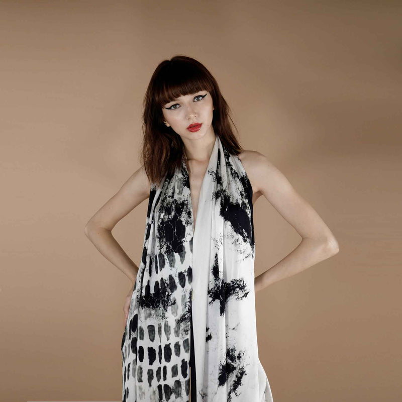 Front view of the black abstract brush-stroke print scarf worn as a halter wrap dress