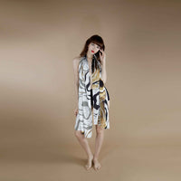Model wearing the grey and gold marbled print scarf draped off-shoulder