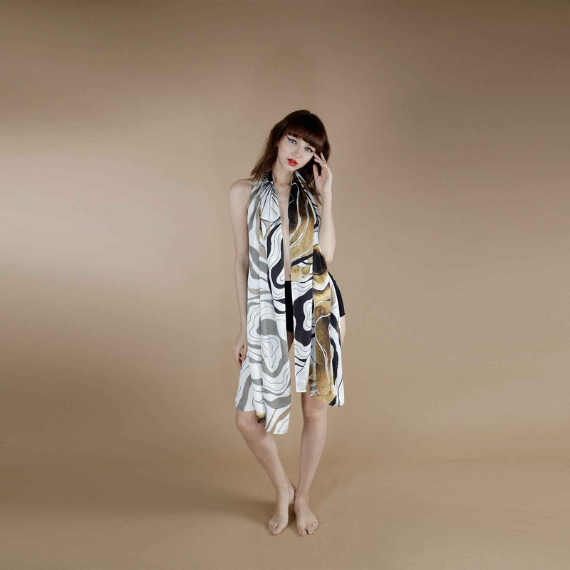Model wearing the grey and gold marbled print scarf draped off-shoulder