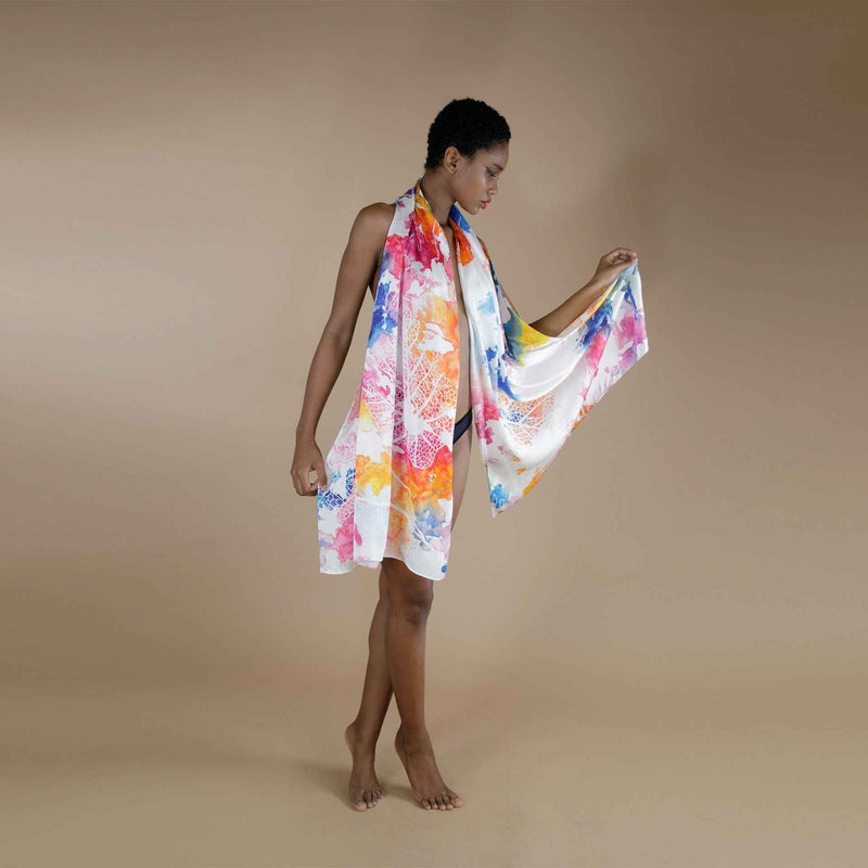 Model holding out the multicolor watercolor splash print scarf to show its full spread