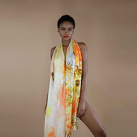 Close-up front view of the yellow and orange floral print scarf draped as a halter dress