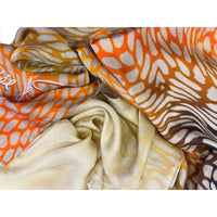Close-up of the orange and beige butterfly print scarf fabric, gathered