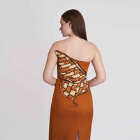 Close-up back view of the rust orange strapless dress showing the butterfly wing print detail