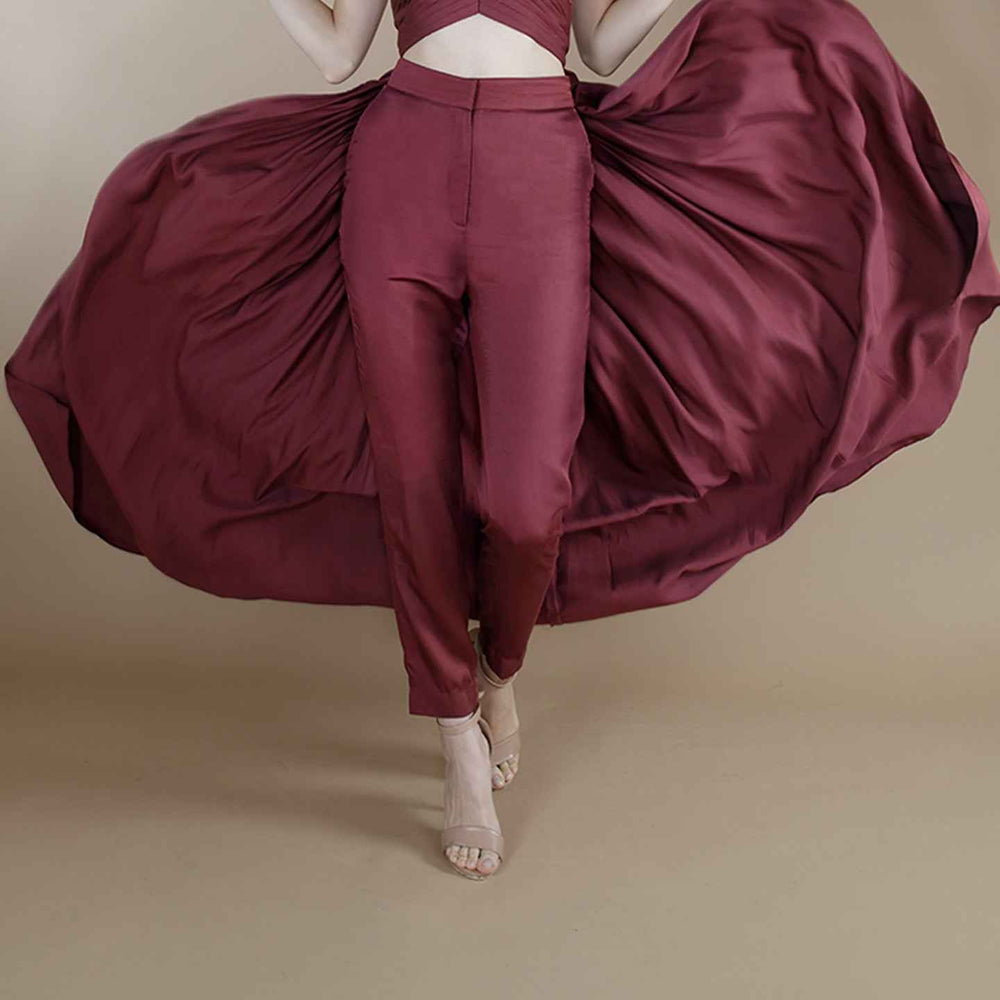 Close-up front view of the wine solid straight-cut trousers, styled with a flowing pleated top