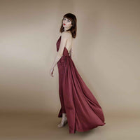 Side view of the maroon halter top with the pleated cape flowing behind