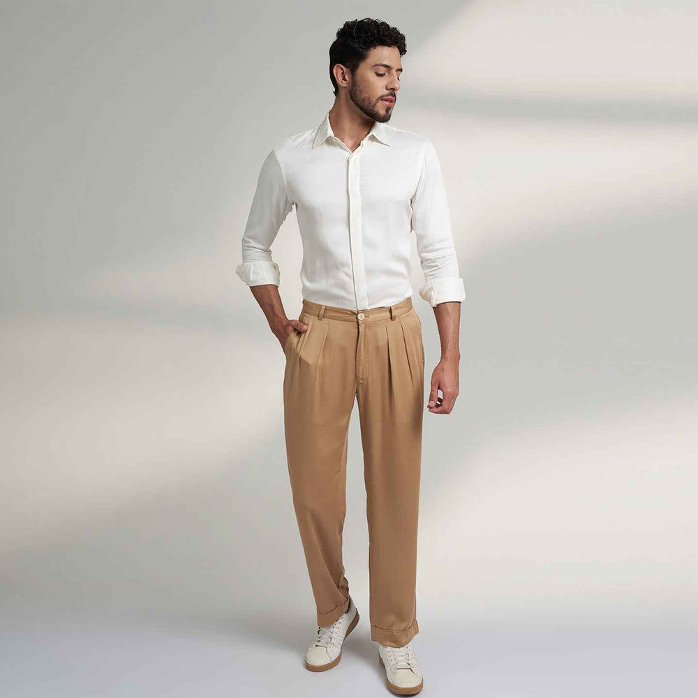 Front view of the beige pleated trousers styled with a white shirt