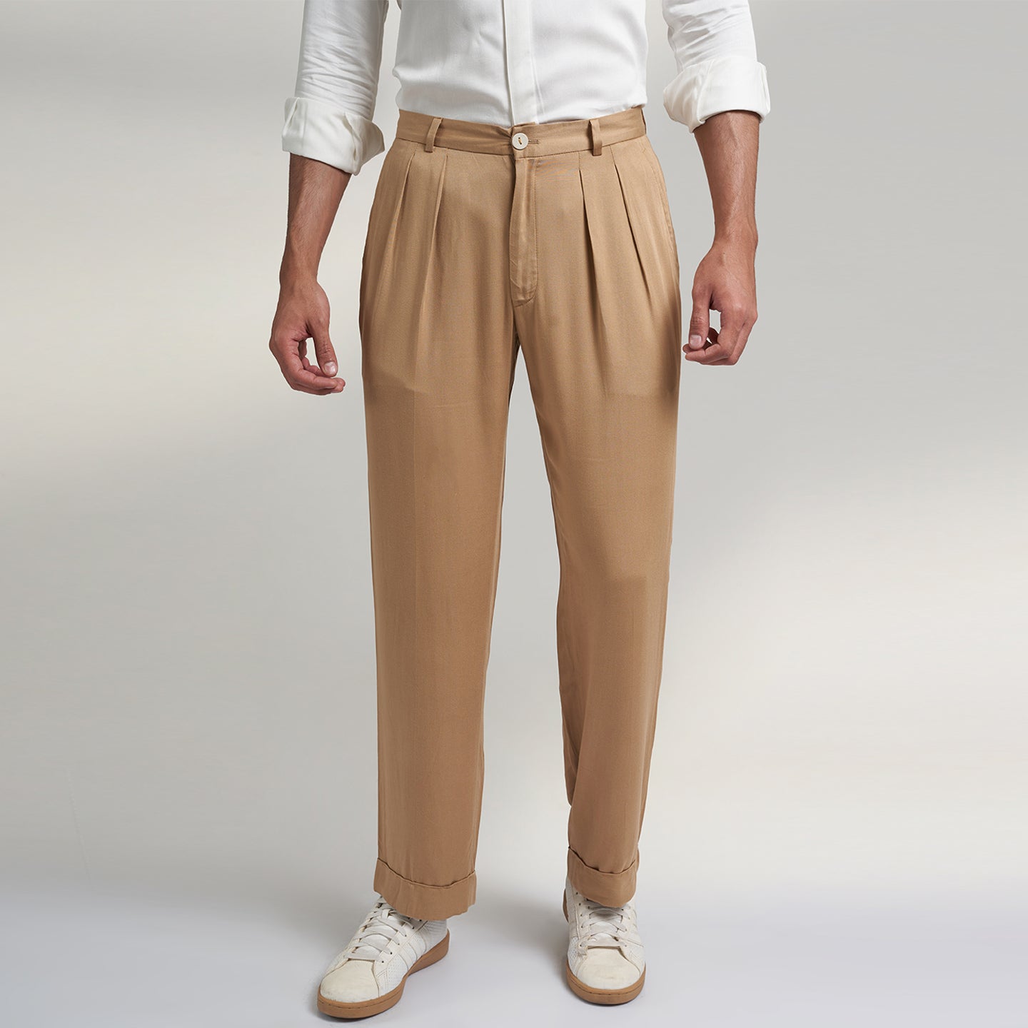 a medium size model wearing beige color trouser made from organic lotus silk fabric. the pant is a basic straight fit with 2 pleats and turn up bottom. 