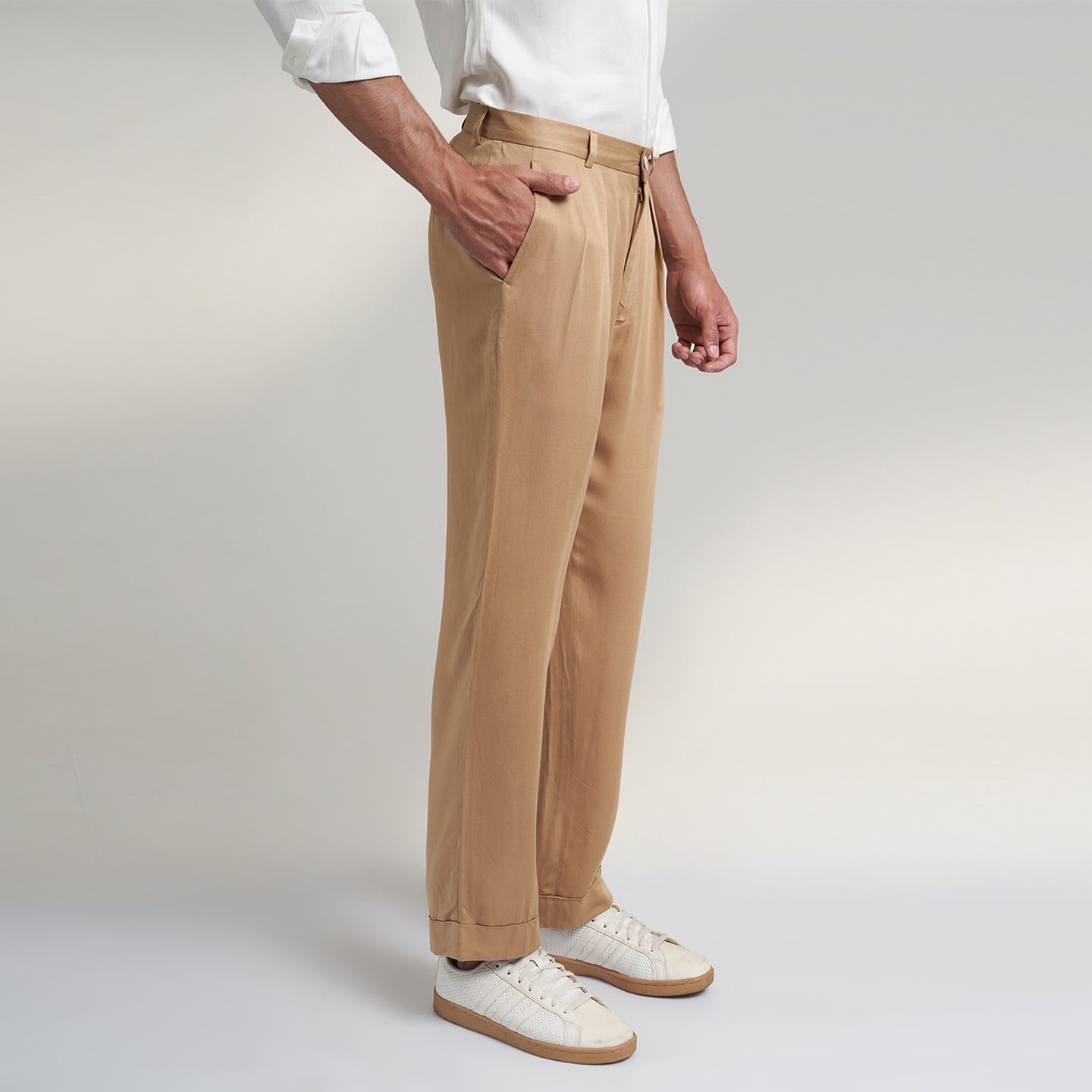 a medium size model wearing beige color trouser made from organic lotus silk fabric. the pant is a basic straight fit with 2 pleats and turn up bottom. 