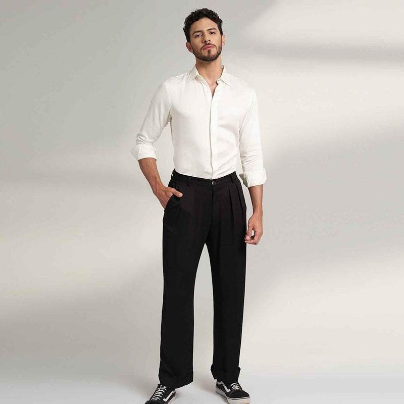Front view of the black pleated trousers styled with a white shirt
