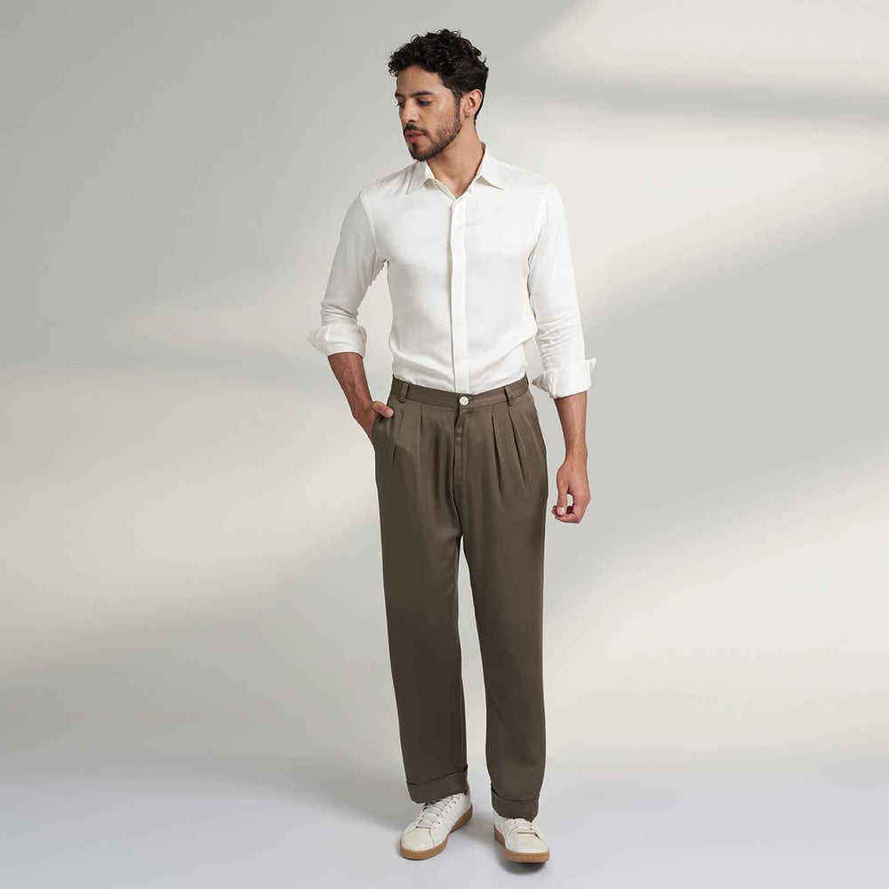 Front view of the olive green pleated trousers styled with a white shirt