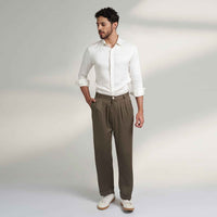 Front view of the olive green pleated trousers styled with a white shirt