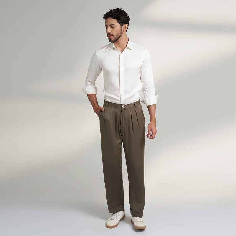 Front view of the olive green pleated trousers styled with a white shirt