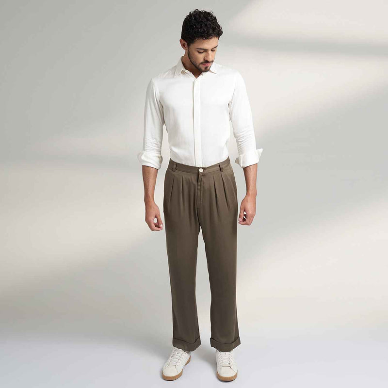 Front view of the olive green pleated trousers, full length with a white shirt