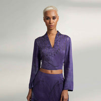 Close-up front view of the purple tonal floral print crop top with a V-neckline