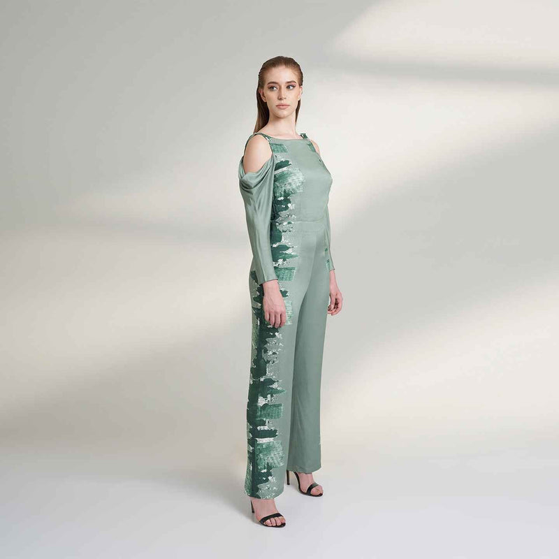 Side view of the sage green cold-shoulder jumpsuit with tonal floral print side panel