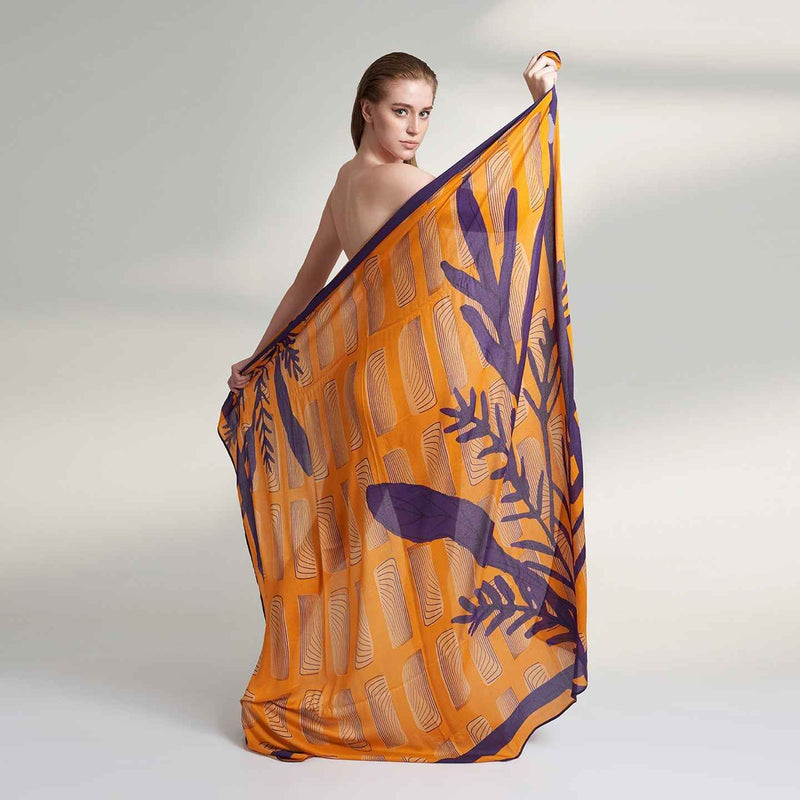 Model holding out the orange and purple leaf print scarf, back view