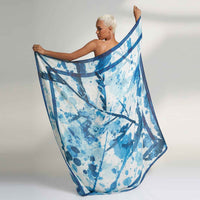 Model holding out the blue and white splatter print scarf, back view