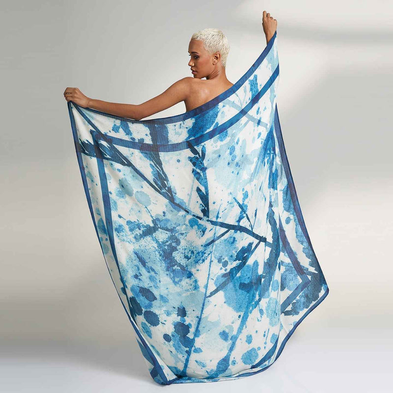 Model holding out the blue and white splatter print scarf, back view