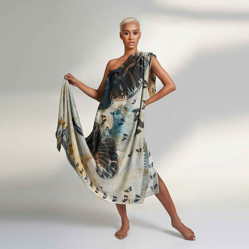 Model wearing the gold and navy butterfly print scarf as a one-shoulder wrap dress