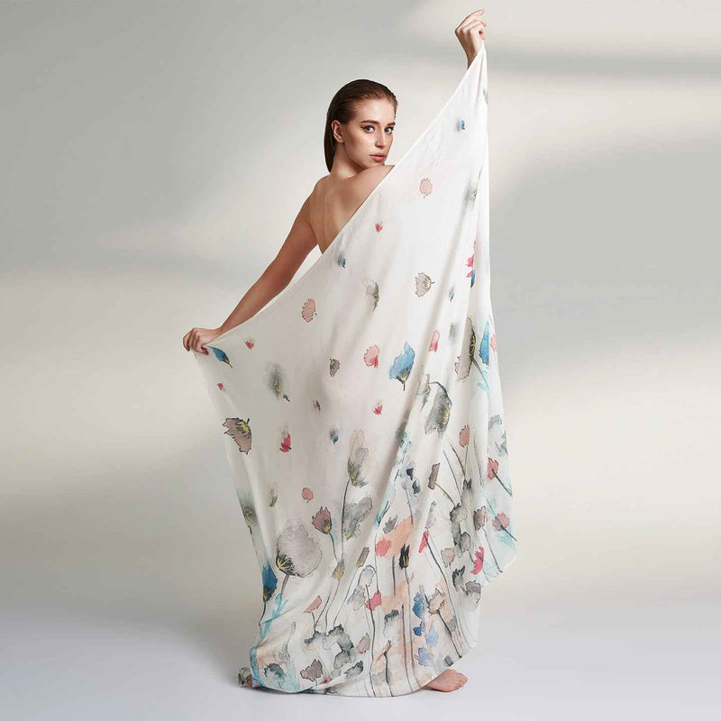 Side view of the model draped in the white floral print scarf
