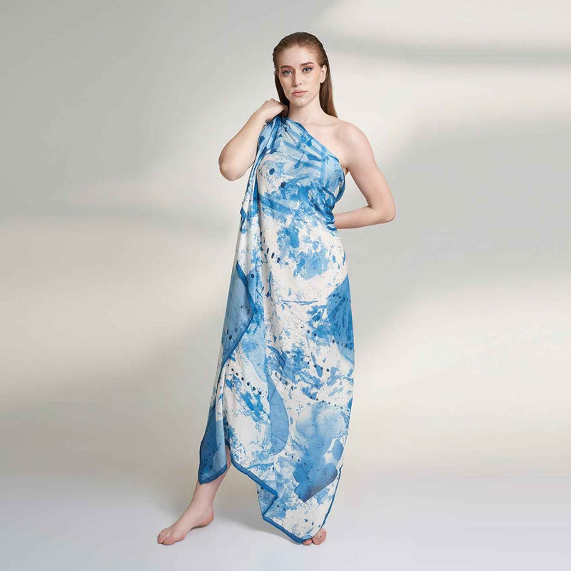 Front view of the model wearing the blue and white splatter print scarf as a one-shoulder wrap dress