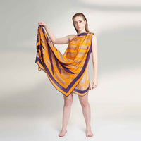Model holding out the orange and purple striped scarf to show its full spread